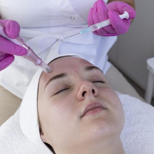 cosmetologist-applying-peeling-mesotherapy-injection-with-dermapen-face-forehead-area_1048944-22587189